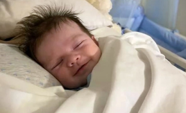 O beb que dorme sorrindo, sem saber que a me morreu aps o parto